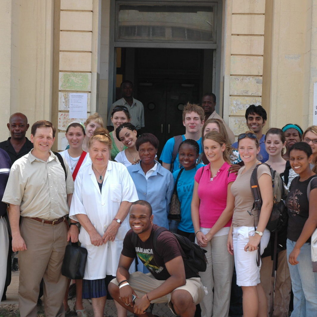 group of medical staff and other people standing outside the entrance to a building